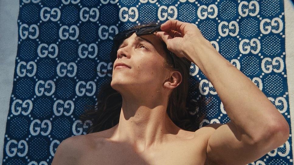 Man shading his eyes on a patterned towel